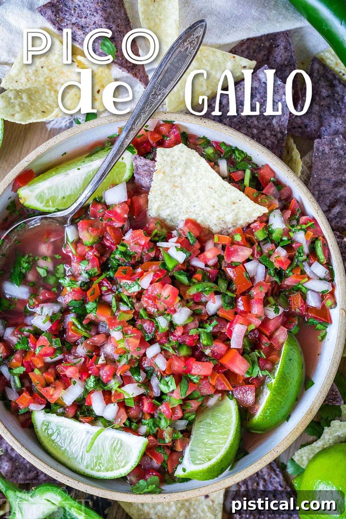 Top-down view of vibrant Pico de Gallo in a rustic clay bowl, garnished with fresh lime wedges and surrounded by crispy tortilla chips. The image highlights the fresh ingredients and appetizing presentation of this classic salsa.