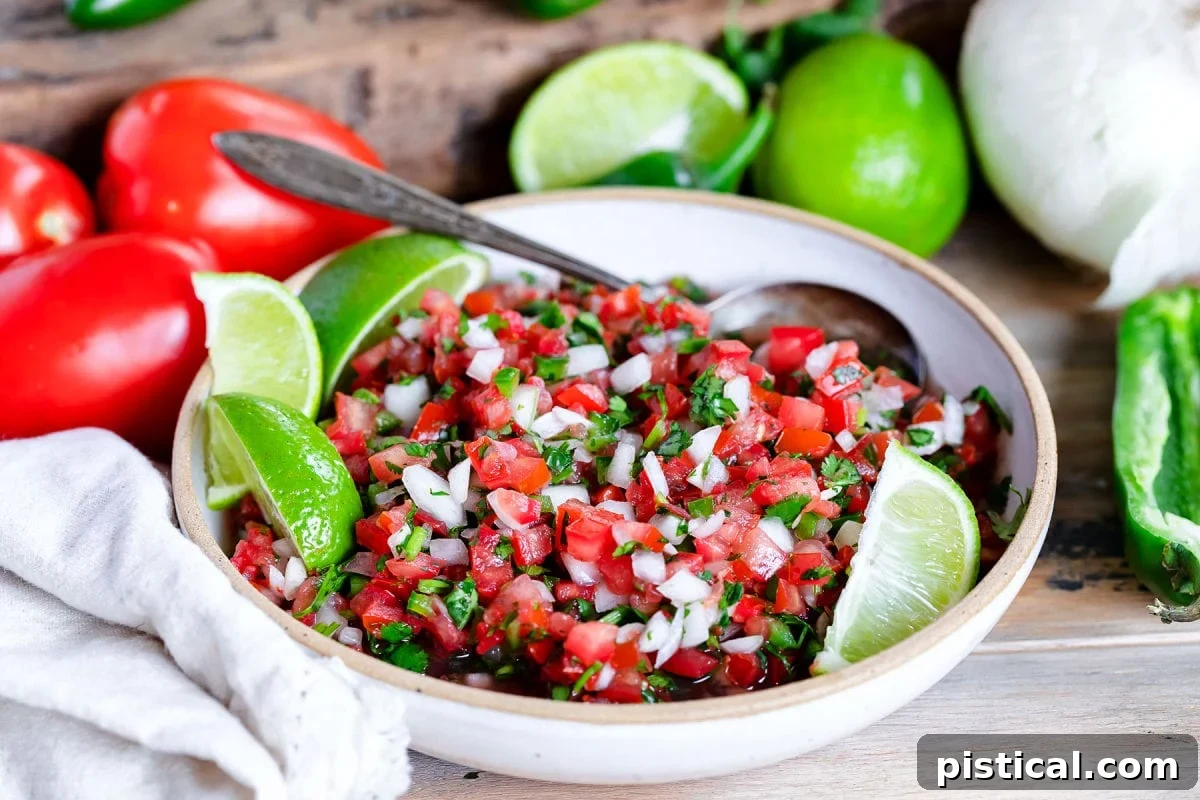 A bowl of salsa fresco, or Pico de Gallo, ready to be enjoyed, with its fresh ingredients beautifully visible and more whole ingredients subtly blurred in the background, creating an appealing culinary scene.