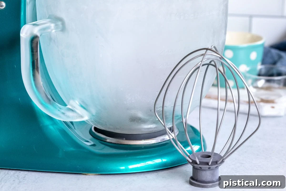 A cold mixing bowl and whisk attachment ready to be used for making whipped cream.