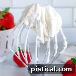 Homemade whipped cream on a whisk attachment.