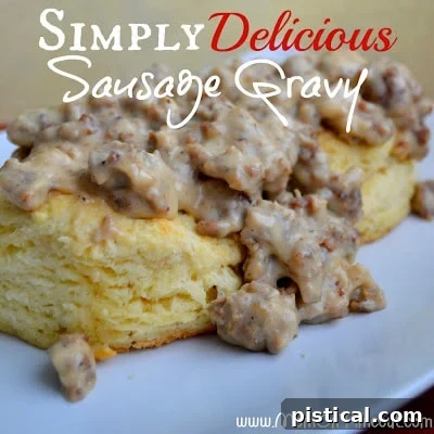 A comforting image of warm biscuits generously covered with creamy homemade sausage gravy on a rustic plate.