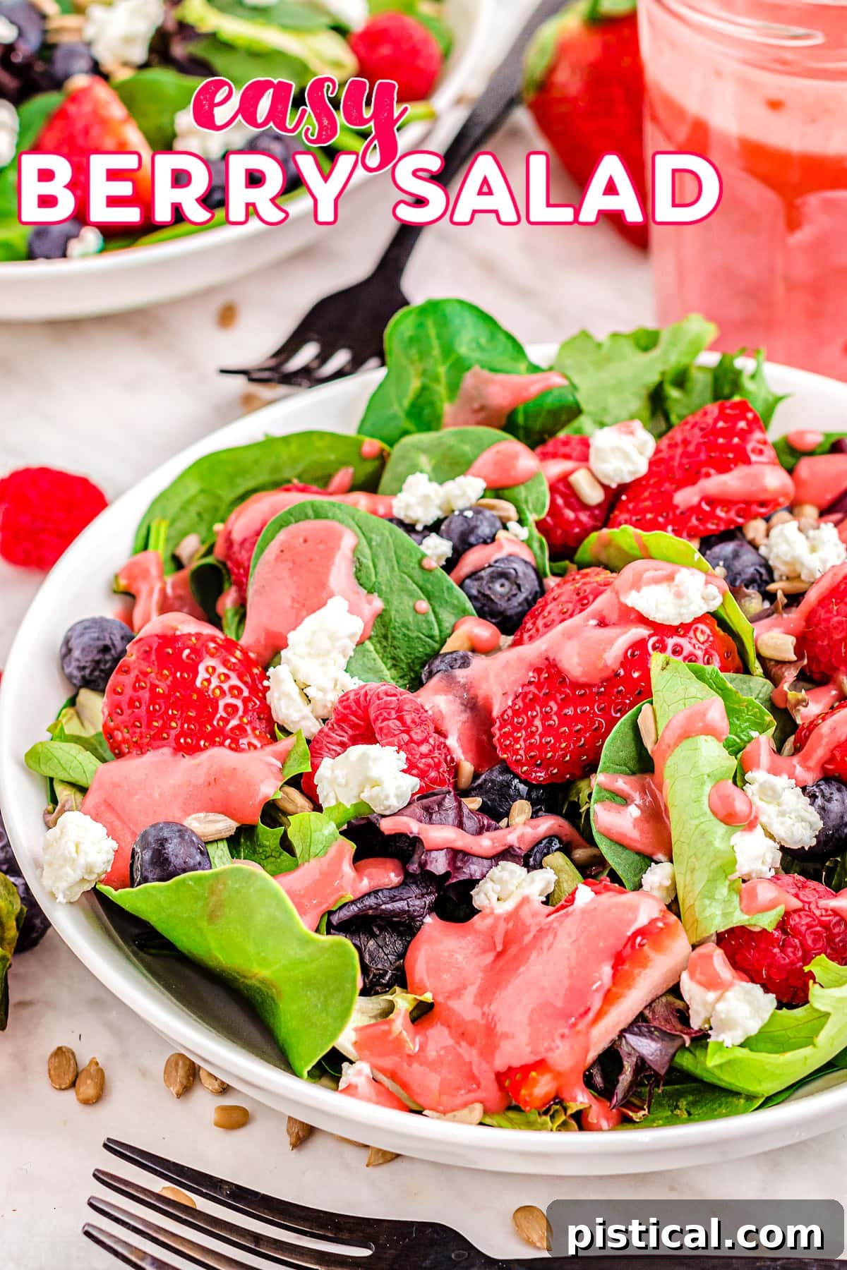 Top-down view of a vibrant berry salad featuring fresh raspberries, strawberries, and blueberries on a white plate, ready to be served.