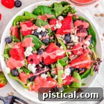 Top-down view of a ready-to-serve berry salad with raspberry vinaigrette.