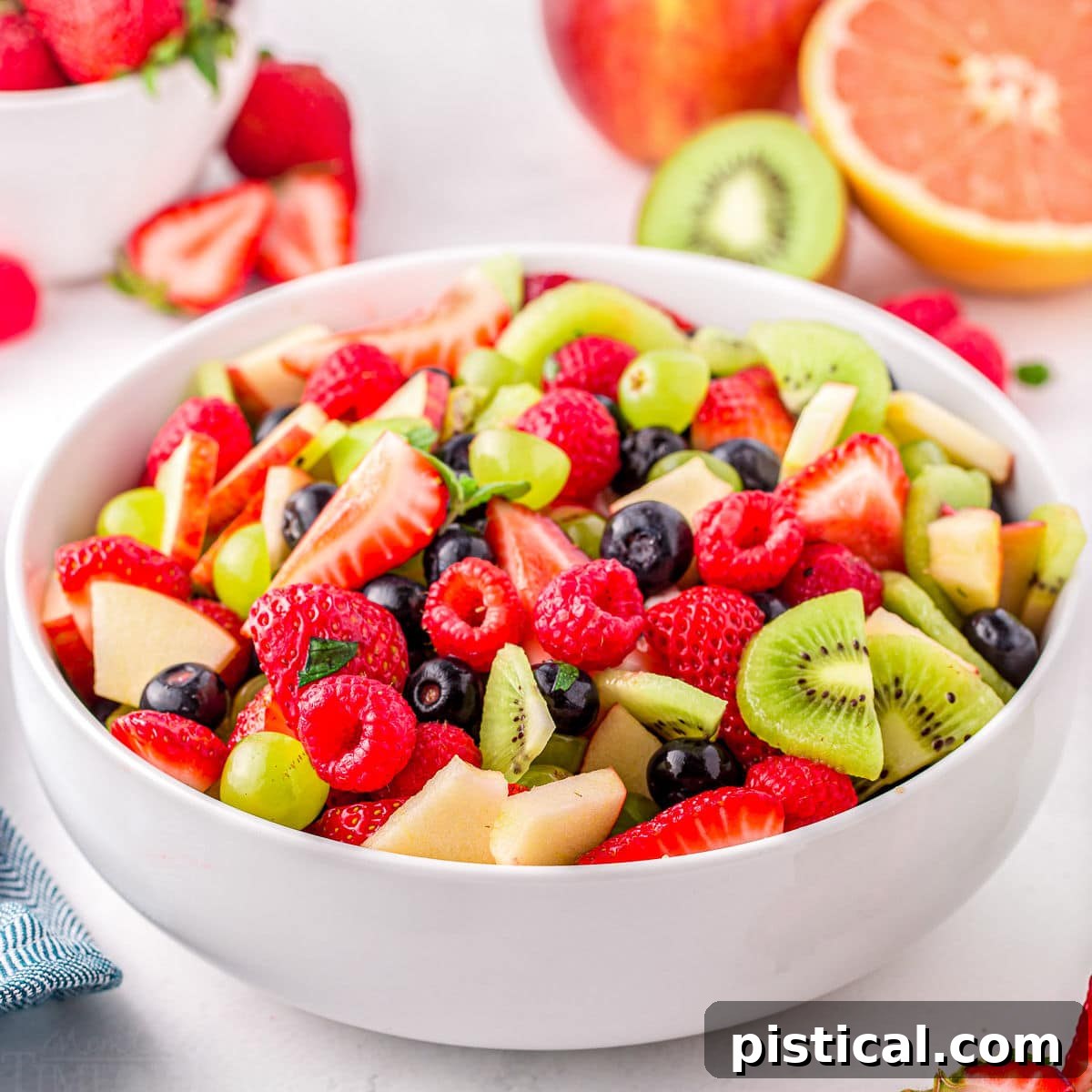 Nature's Candy Bowl 5 A light and refreshing fruit salad featuring a delightful mix of summer fruits, beautifully arranged in a large white serving dish.