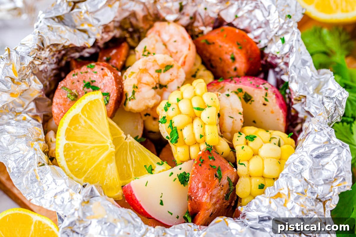 Close up look at shrimp foil packets with corn, potatoes, shrimp, sausage and herbs, showcasing the vibrant colors and textures.