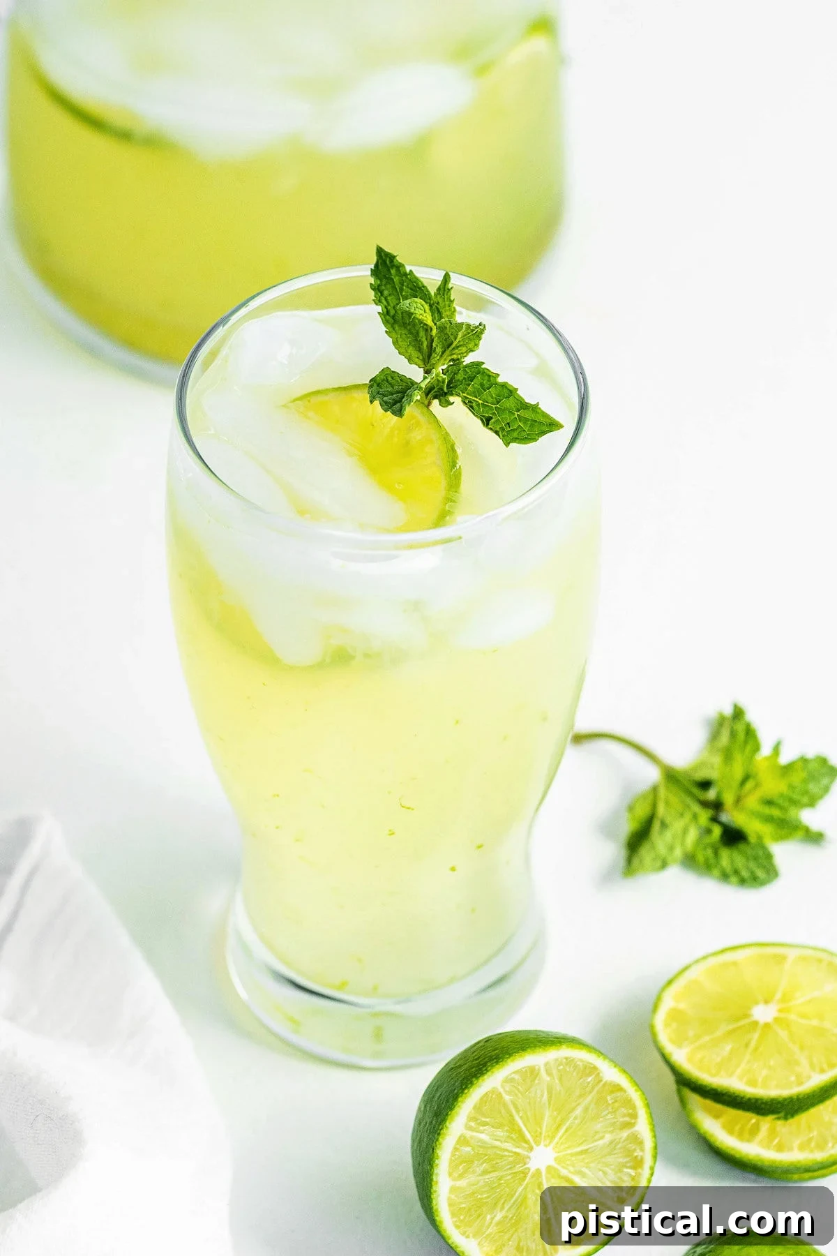 Quick and Refreshing Two Ingredient Limeade 3 top down look at limeade in a tall clear glass topped with a sprig of mint.