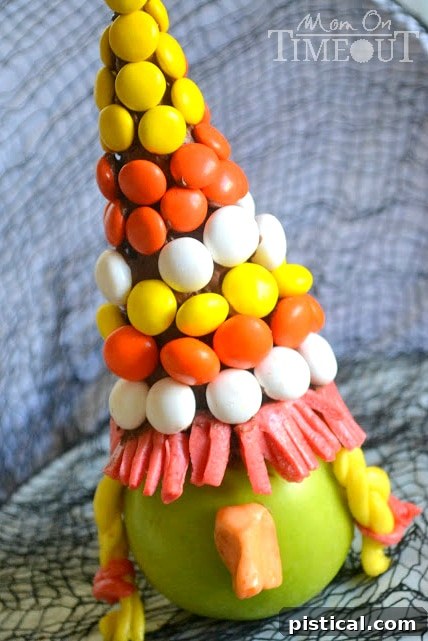 Bewitching Apples - A fun Halloween treat from MomOnTimeout.com Close-up of a finished Bewitching Apple Witch showing the detailed candy hat, Starburst braids, and nose.