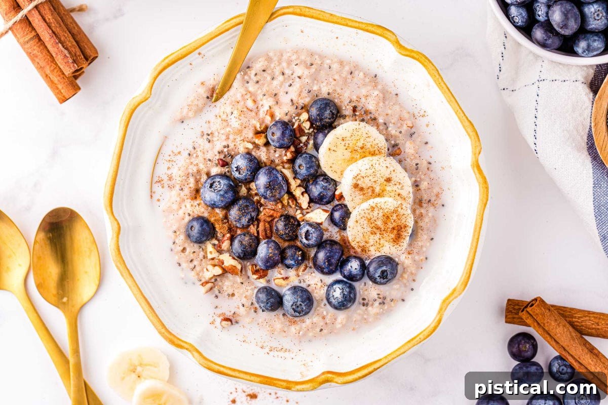 Top-down view of a bowl of oatmeal topped with fresh fruit, pecans, and cinnamon, showcasing a delicious and healthy breakfast.