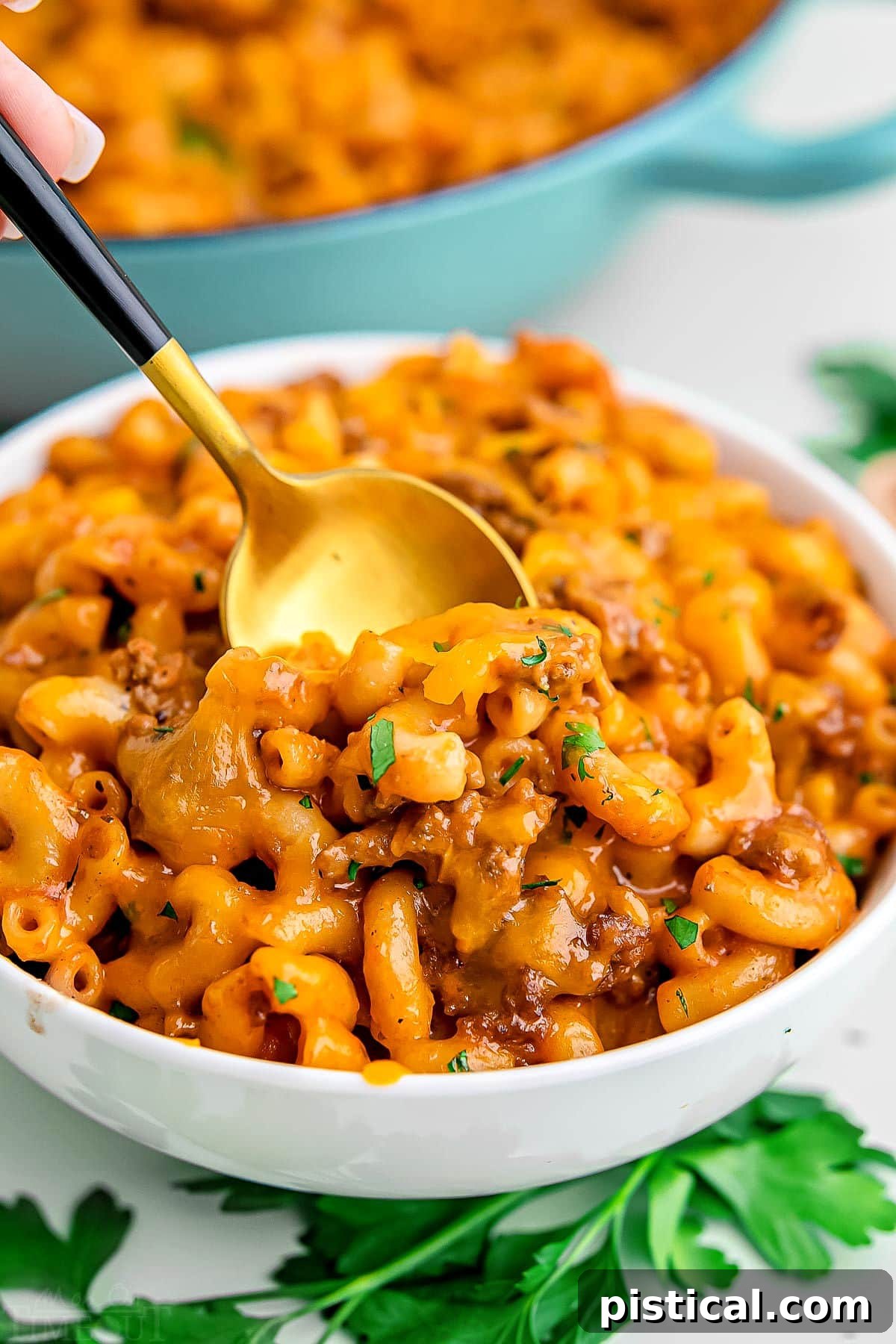 bowl of homemade hamburger helper ready to eat with a gold spoon inserted in the bowl.