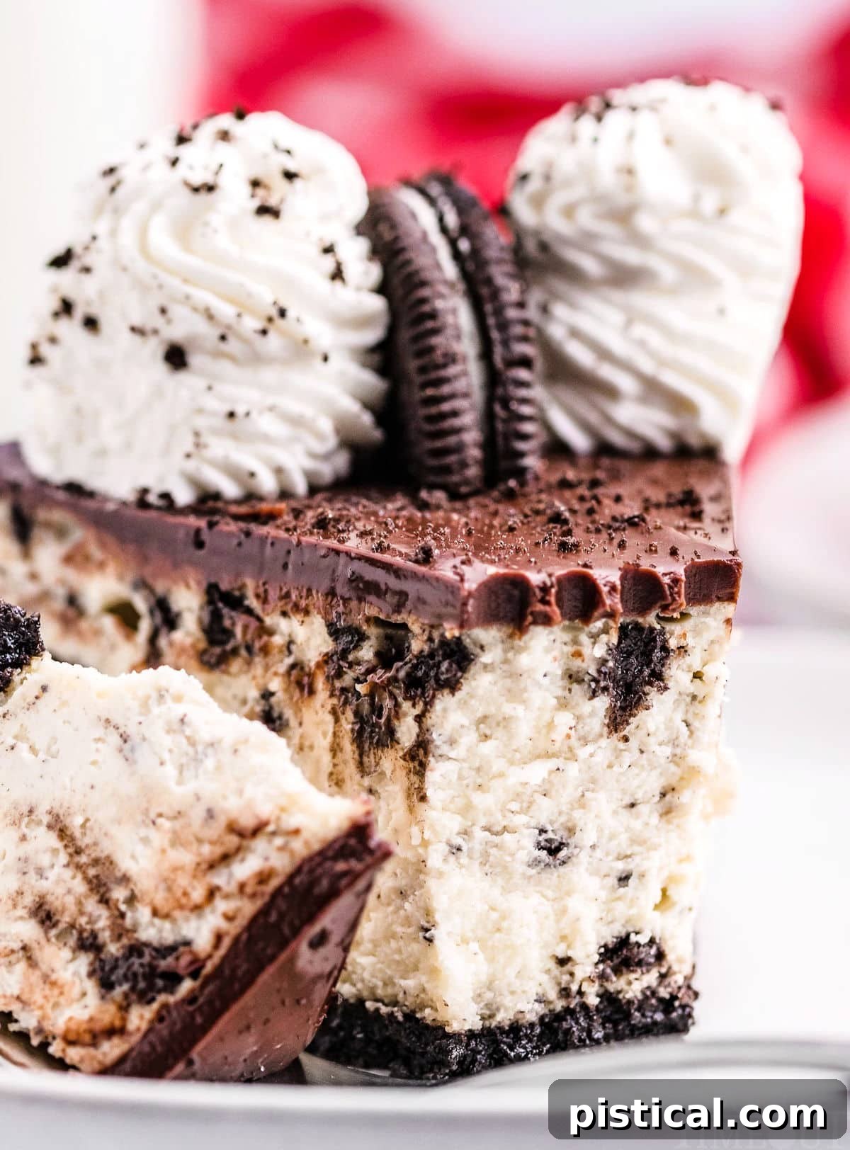 A tantalizing close-up of a creamy Oreo cheesecake slice, showcasing its rich texture and glossy chocolate ganache topping. A bite has been taken, revealing the cookie-filled interior.