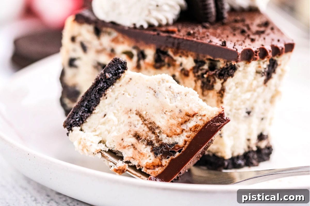 A delectable bite of Oreo cheesecake positioned next to a full slice on a clean white plate, ready to be enjoyed.