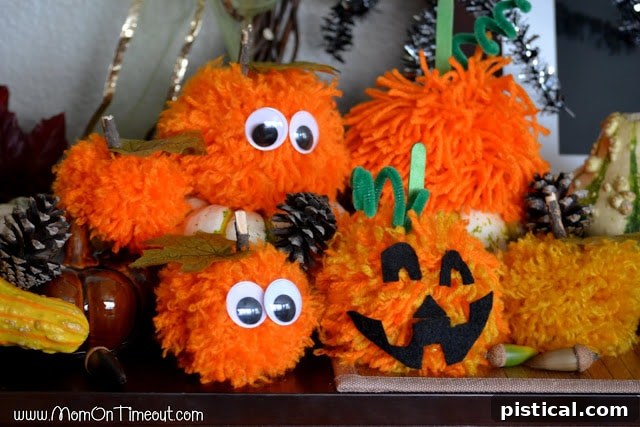 Make these Pom Pom Pumpkins with the kids this Halloween season! Super fun and SO easy too! | MomOnTimeout.com Close-up of an assortment of pom pom pumpkins, showcasing different designs and textures suitable for Halloween and fall. | MomOnTimeout.com