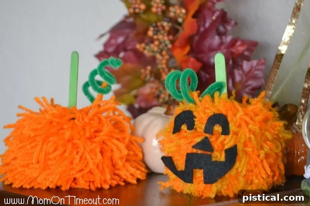 Make these Pom Pom Pumpkins with the kids this Halloween season! Super fun and SO easy too! | MomOnTimeout.com Two contrasting pom pom pumpkins: one shabby chic, the other a classic jack-o-lantern, showcasing creative design options. | MomOnTimeout.com
