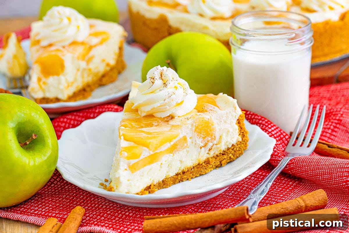 Two perfectly cut slices of apple cheesecake resting on small white plates, set on a warm red placemat, with a refreshing glass of milk softly blurred in the background.