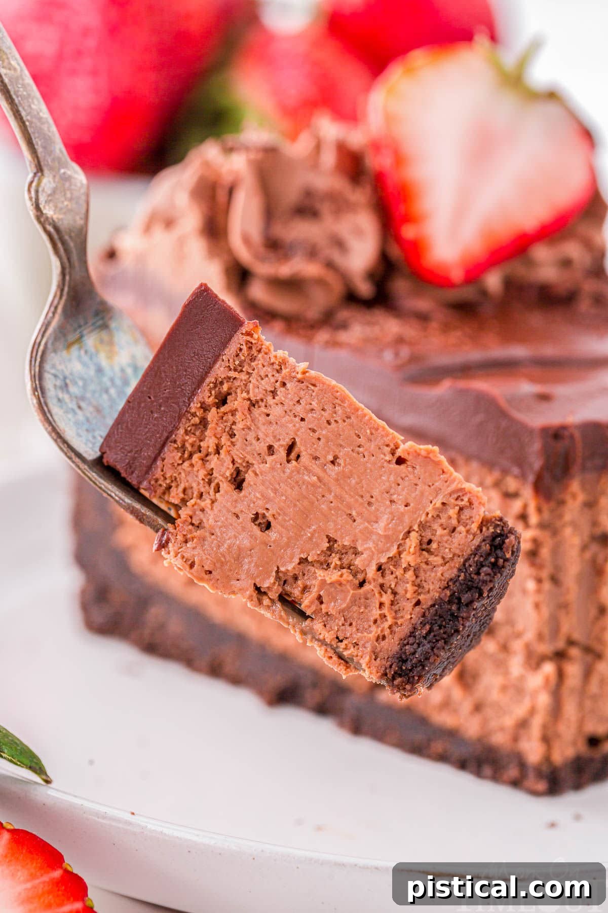 Forkful of chocolate cheesecake pulled away from a slice of cheesecake.