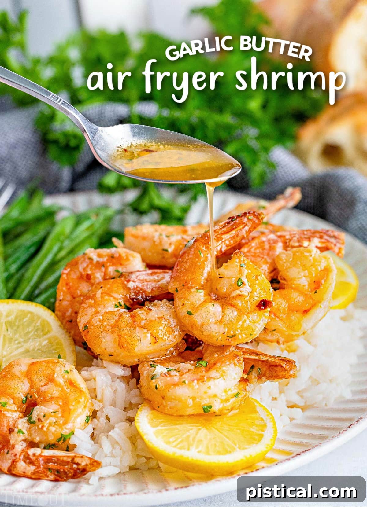 Perfectly cooked air fryer shrimp drizzled with rich garlic herb butter sauce, served with fresh green beans and lemon slices.