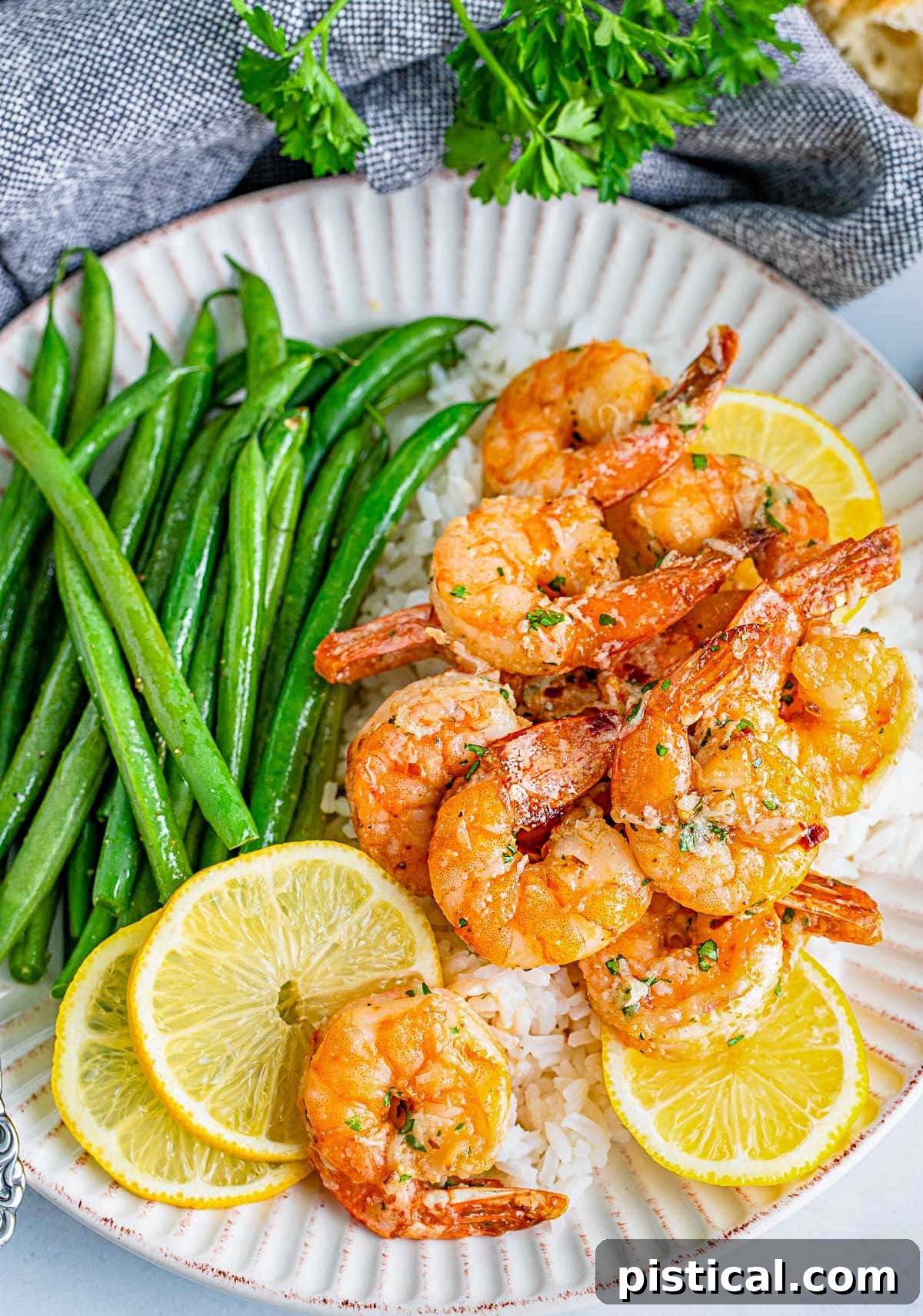 A tantalizing plate of air fryer shrimp generously coated in a homemade garlic herb butter sauce, ready to be enjoyed.
