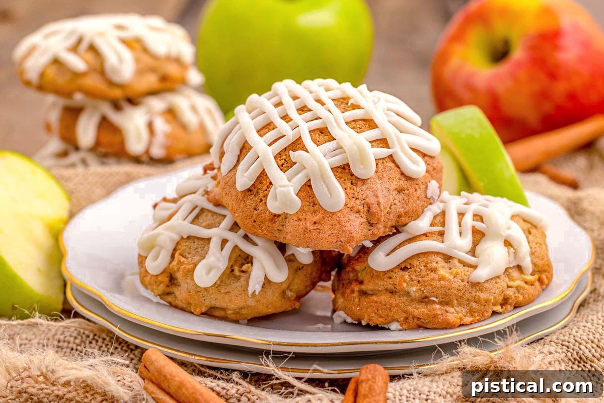 A wide shot of a plate brimming with apple cookies, each featuring a delightful zig-zag drizzle of maple icing.