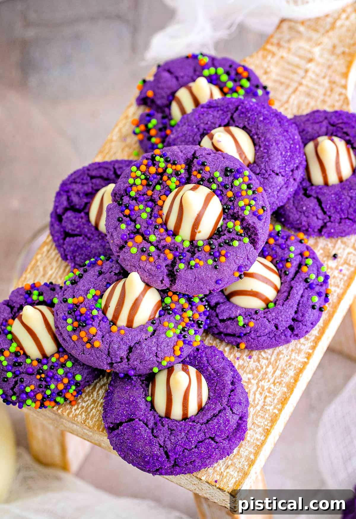top down look at a stack of purple halloween cookies that look like witch hats sitting on a wood riser.