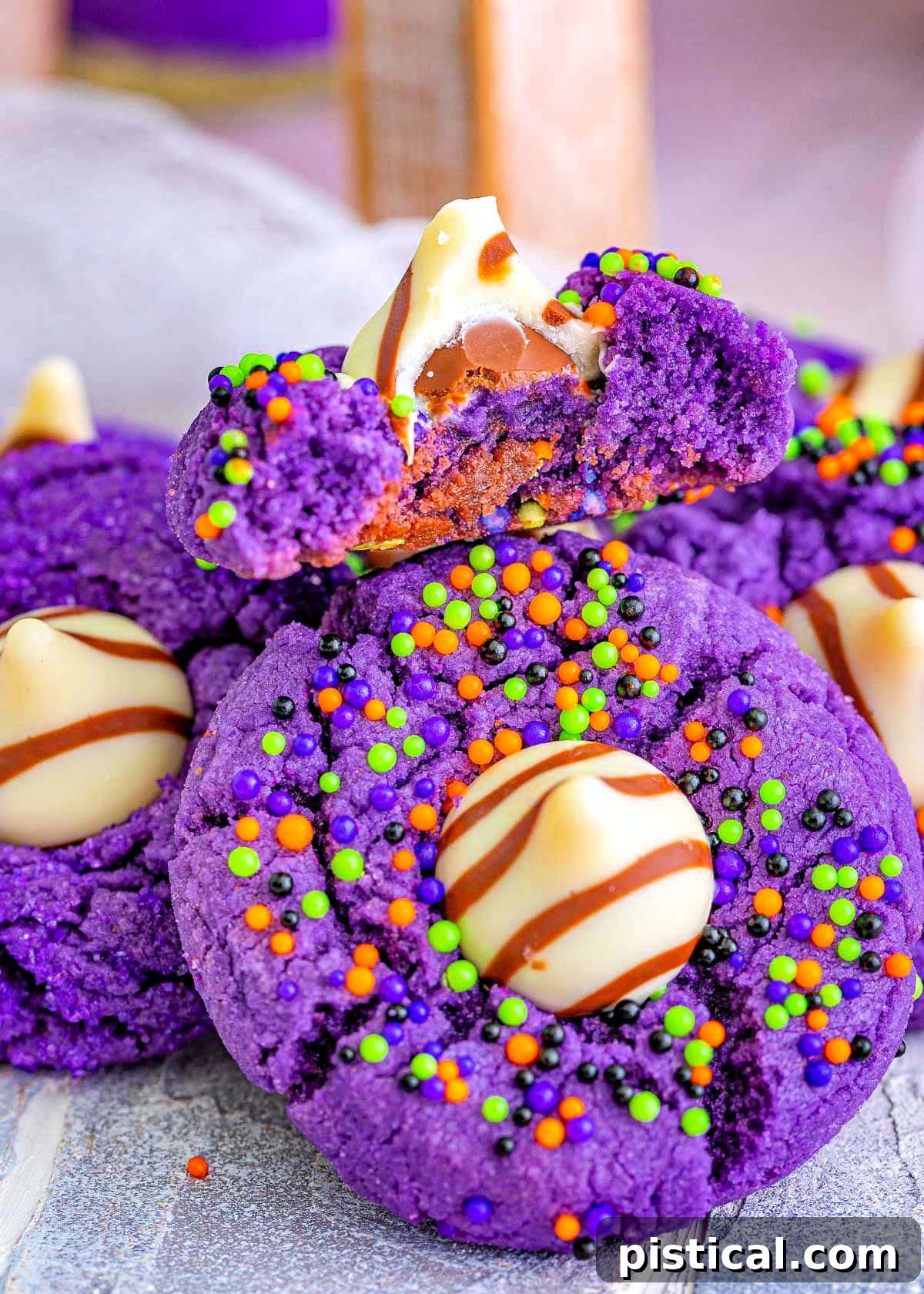 witch hat cookies in a pile with the top cookie bitten in half.