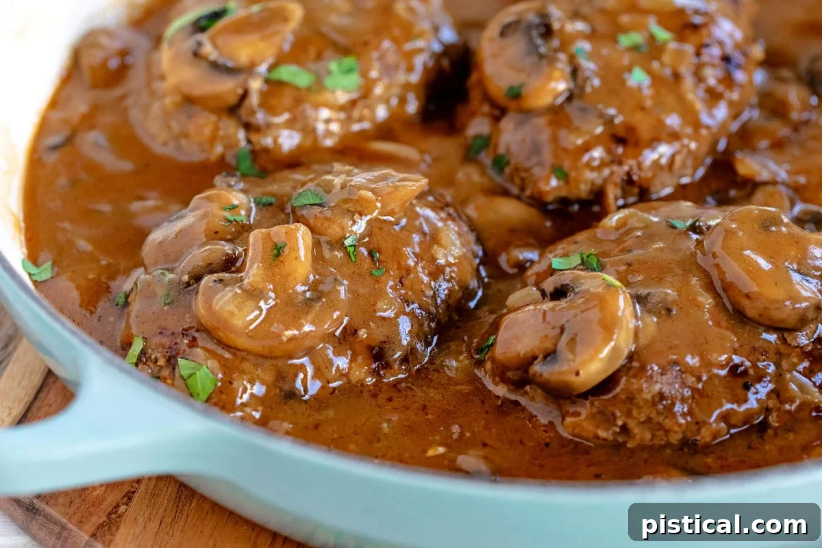 wide shot of salisbury steaks in aqua skillet ready to be served. 