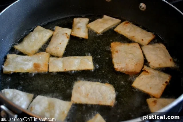 Flour tortilla chips frying in hot oil until golden brown