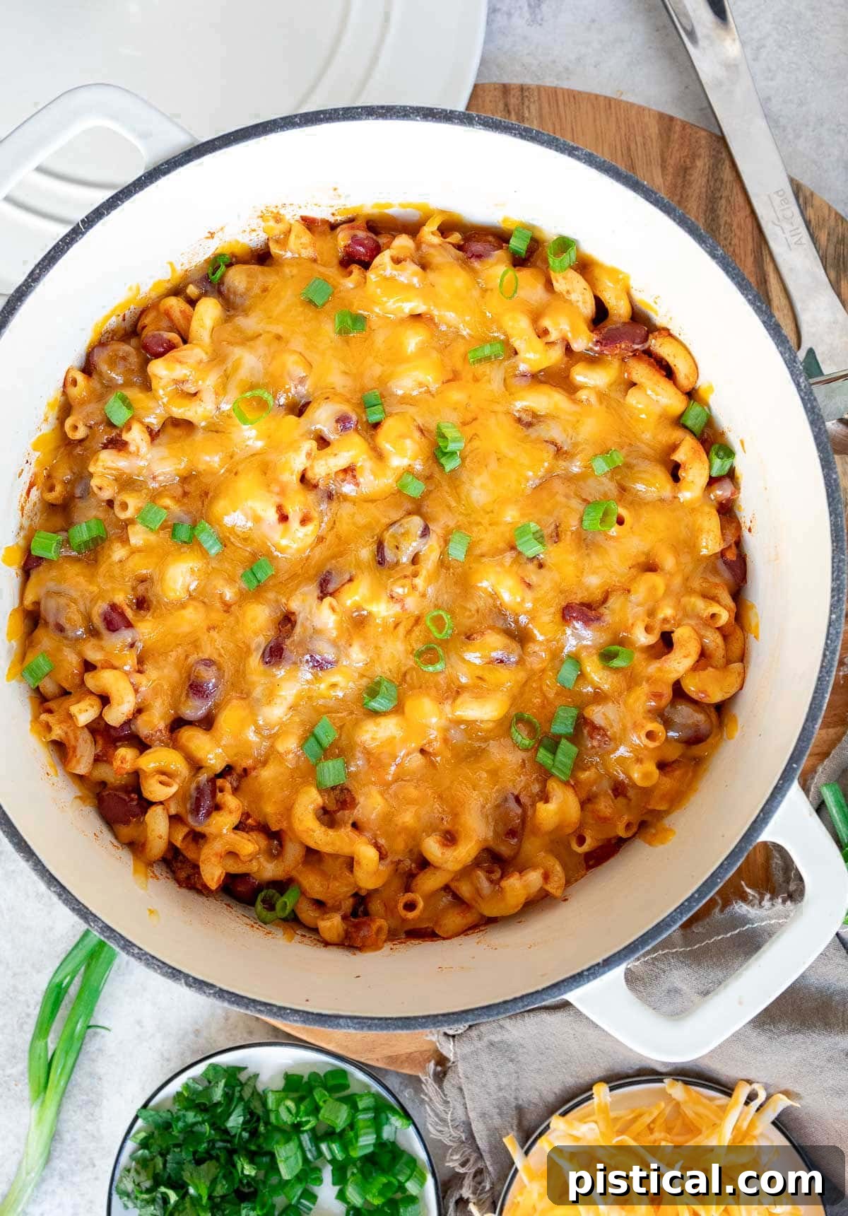 top down look at chili and macaroni in white dutch oven.