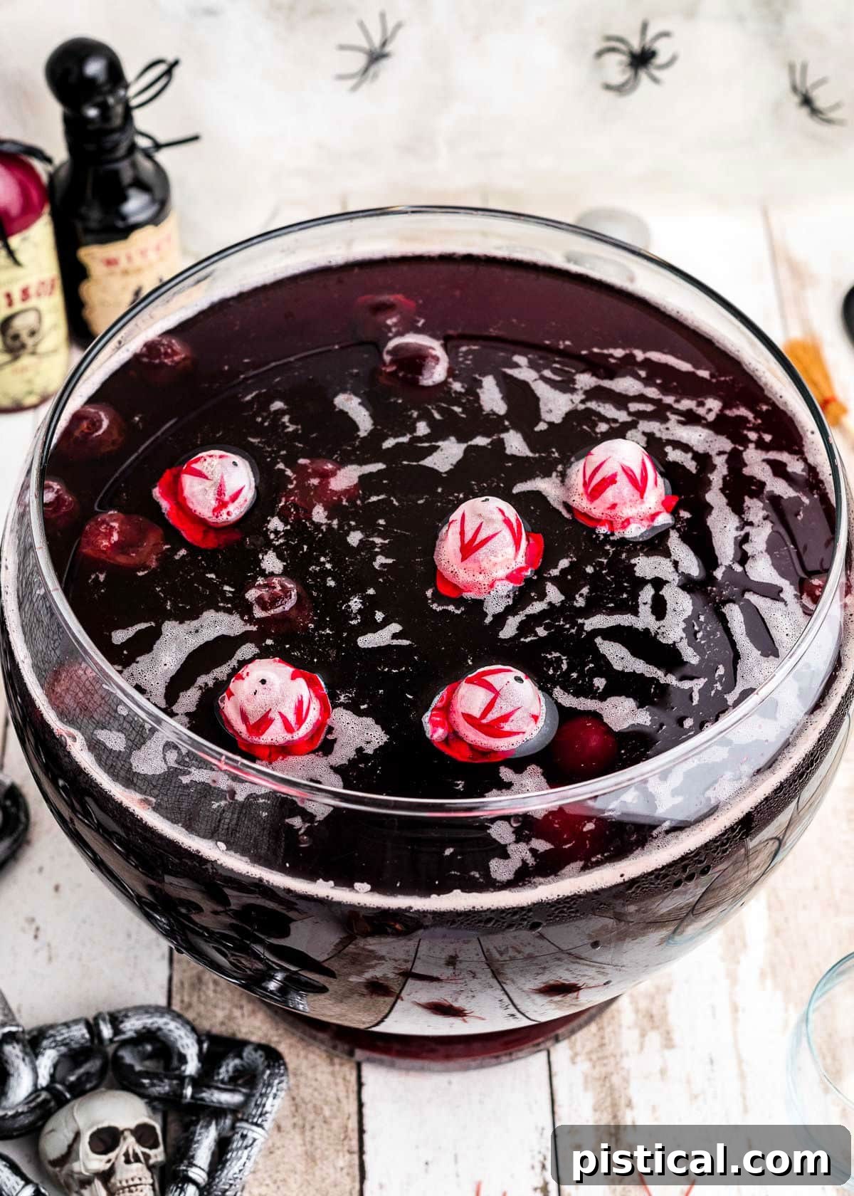 Eerie Elixir 6 A top-down view of Halloween punch in a clear glass punch bowl, featuring floating skull ice cubes and a vibrant deep red hue.