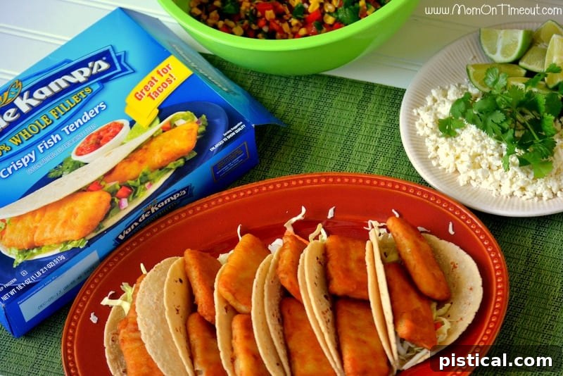 Hands assembling fish tacos with various toppings on a counter