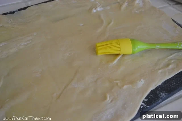Cinnamon sugar sprinkled over buttered dough