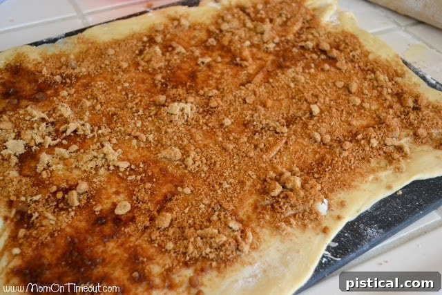 Diced apples and caramel drizzled over cinnamon sugar on dough