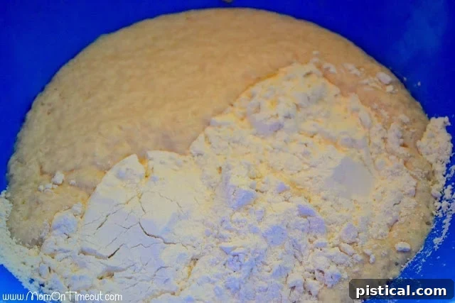 Rising yeast dough in a mixing bowl covered with plastic wrap