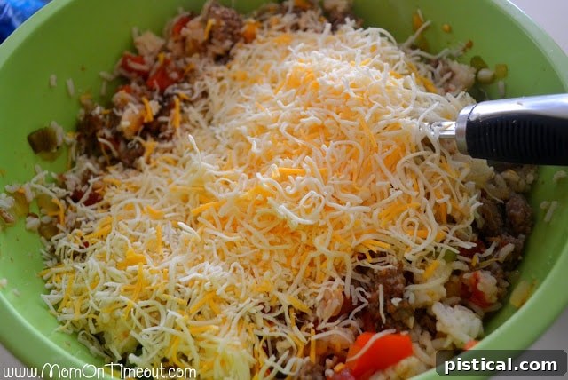 Adding and mixing shredded cheese into the stuffed pepper filling