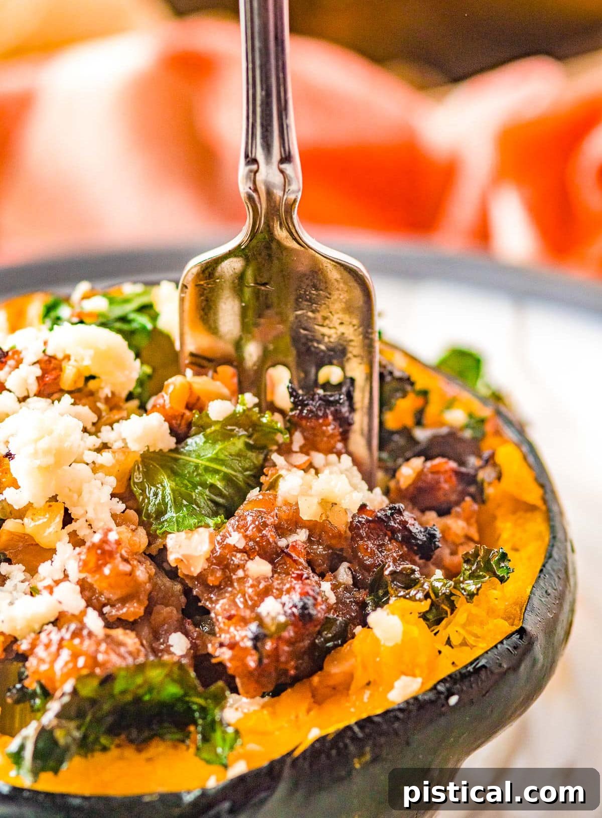 A fork piercing into a stuffed acorn squash half, filled with a hearty sausage mixture.