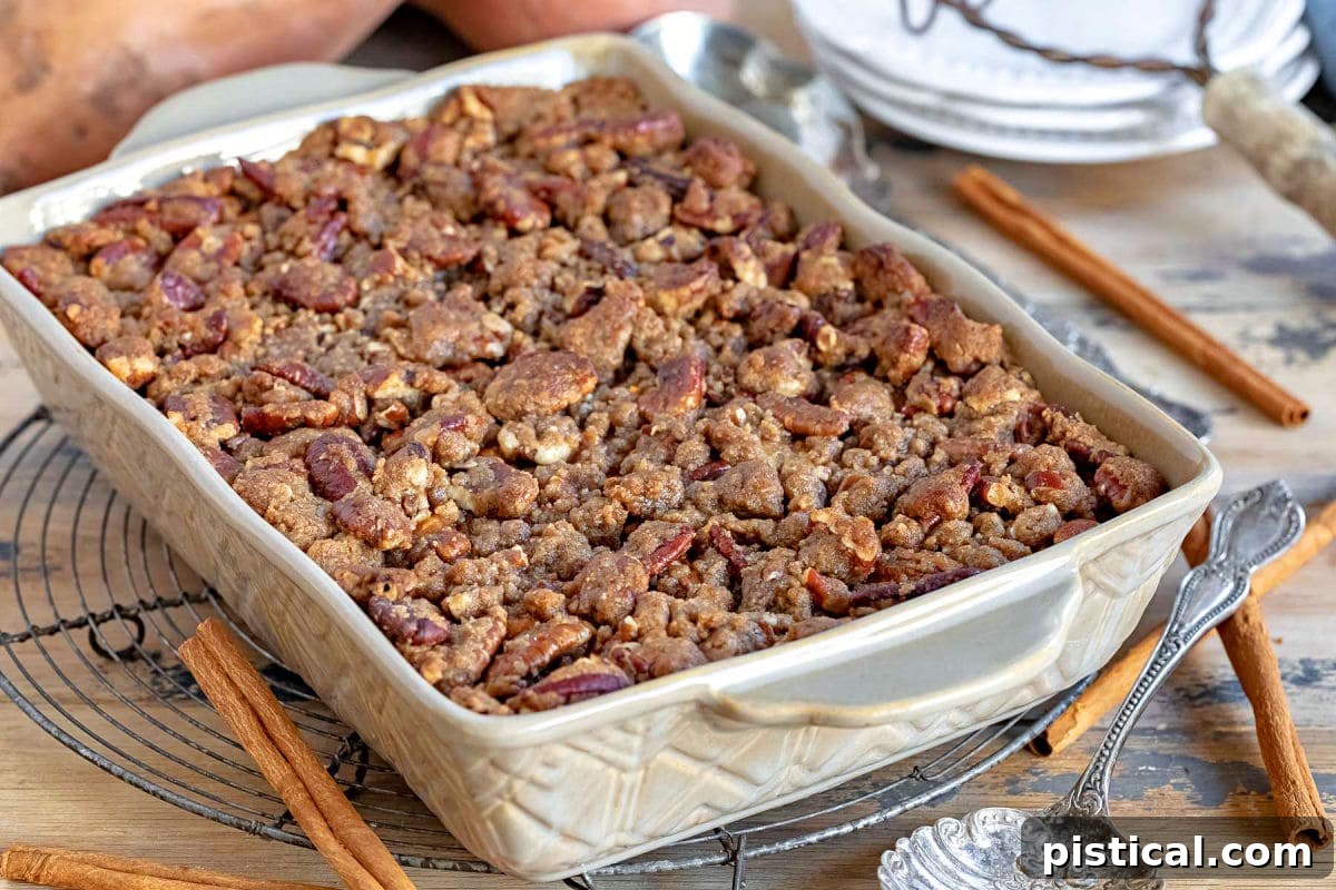 A rustic brown baking dish containing a freshly baked sweet potato casserole, cooling on a wire rack, ready to be served.