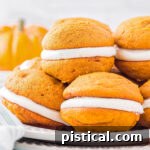 A plate with six pumpkin whoopie pies stacked on each other, looking delicious and ready to be served.