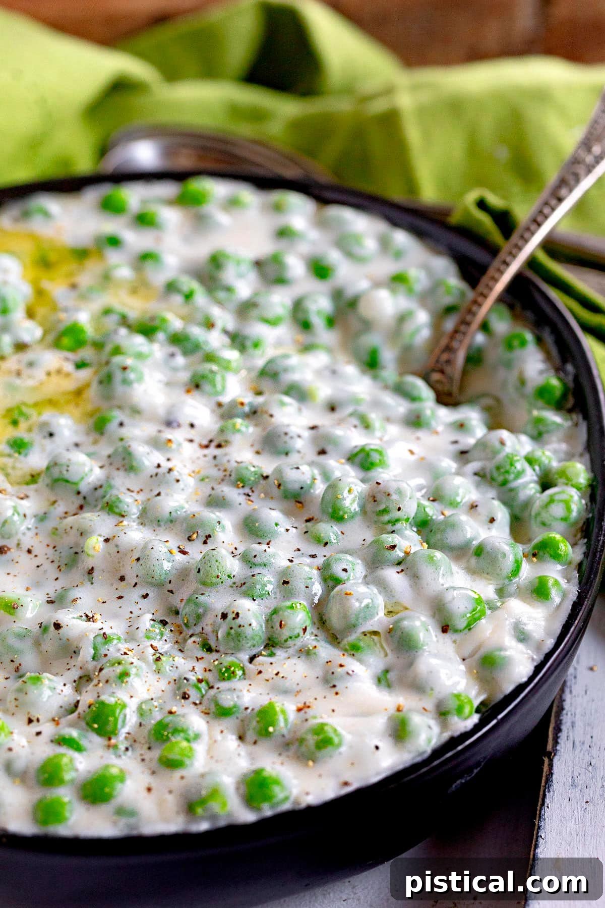 Creamed peas in a deep black bowl, presenting a rich and inviting texture, ready to be enjoyed.