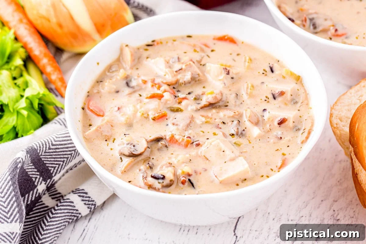 white bowl filled with turkey soup made with leftover turkey and wild rice.