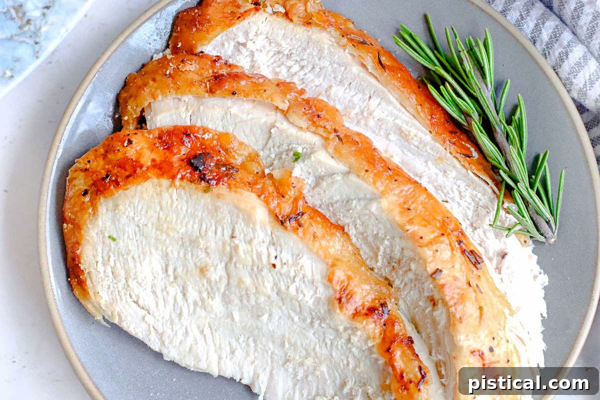 three slices of turkey breast sitting on plate with rosemary sprig to the side.