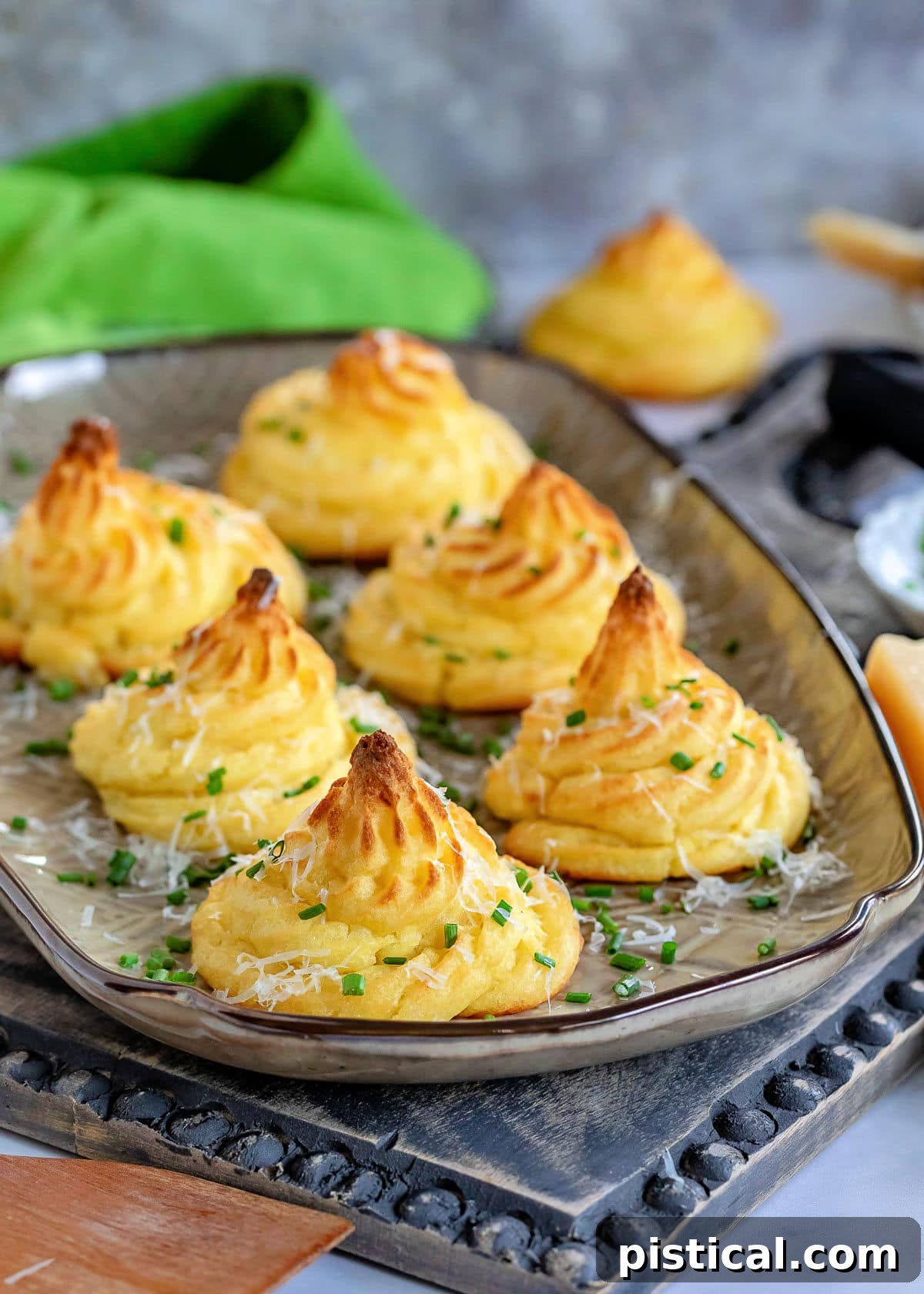 Golden Potato Swirls 2 large brown tray with six duchess potatoes garnished with Parmesan cheese and snipped chives.