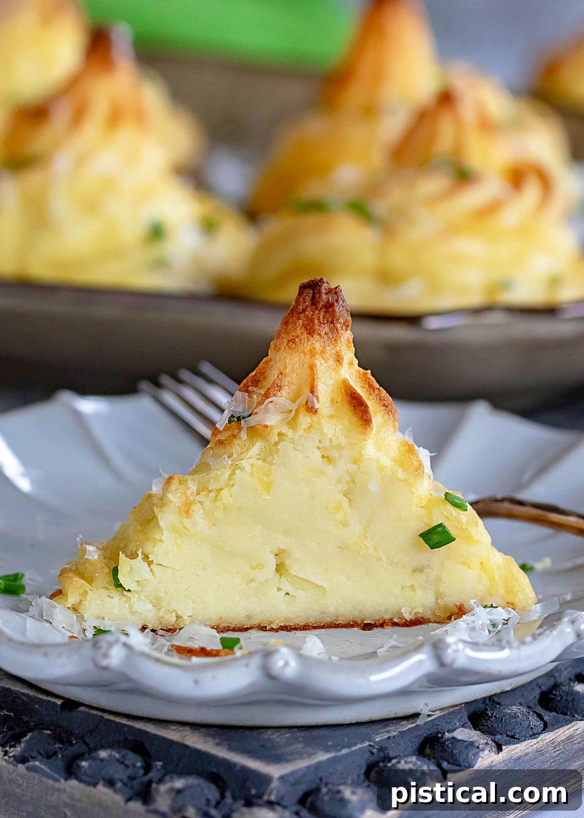 Golden Potato Swirls 3 one duchess potatoes serving cut in half and sitting on a small plate revealing the creamy interior.
