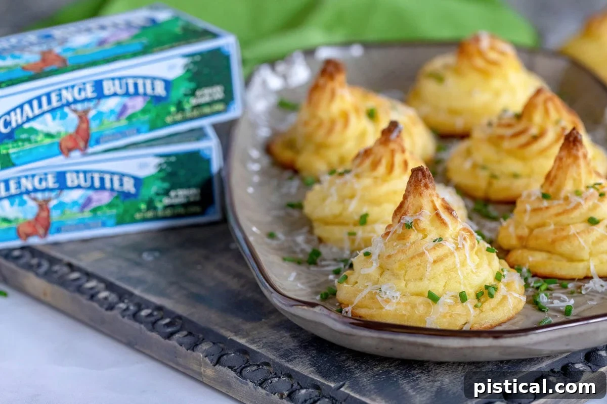 Golden Potato Swirls 4 six duchess potatoes sitting on a brown serving tray with boxes of Challenge butter to the left of the tray.