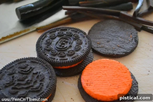 Demonstration of inserting black licorice legs into the creme filling of an Oreo cookie