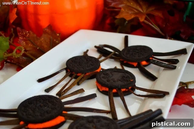 Applying red sparkle gel to the top of an Oreo spider cookie to create the Black Widow's signature mark