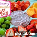 Raspberry Marshmallow Fruit Dip close-up in a bowl with a spoon, surrounded by fresh raspberries.