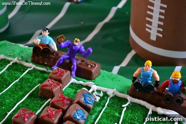 A Snickers mini 'player' has moved to score a touchdown on the cake