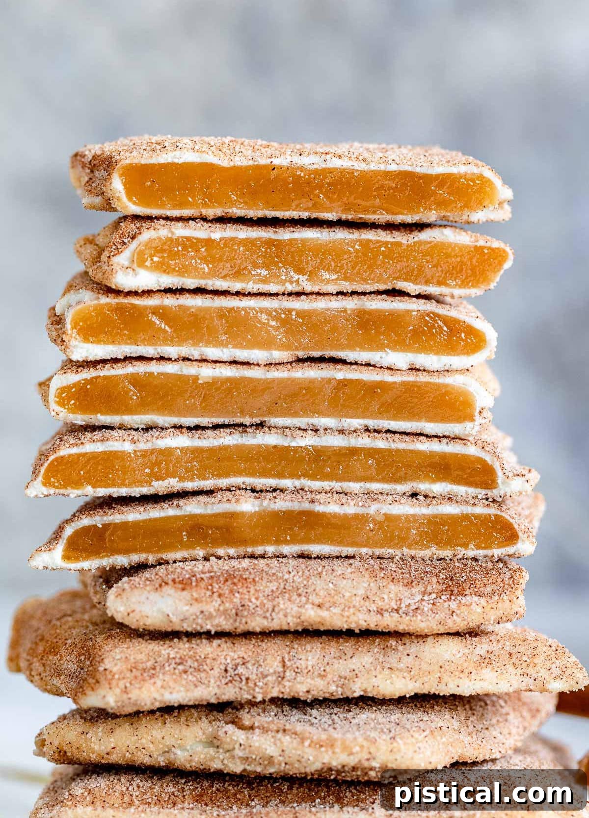 Stacked squares of homemade Churro Toffee, some broken to reveal the toffee base, white chocolate, and cinnamon sugar coating.