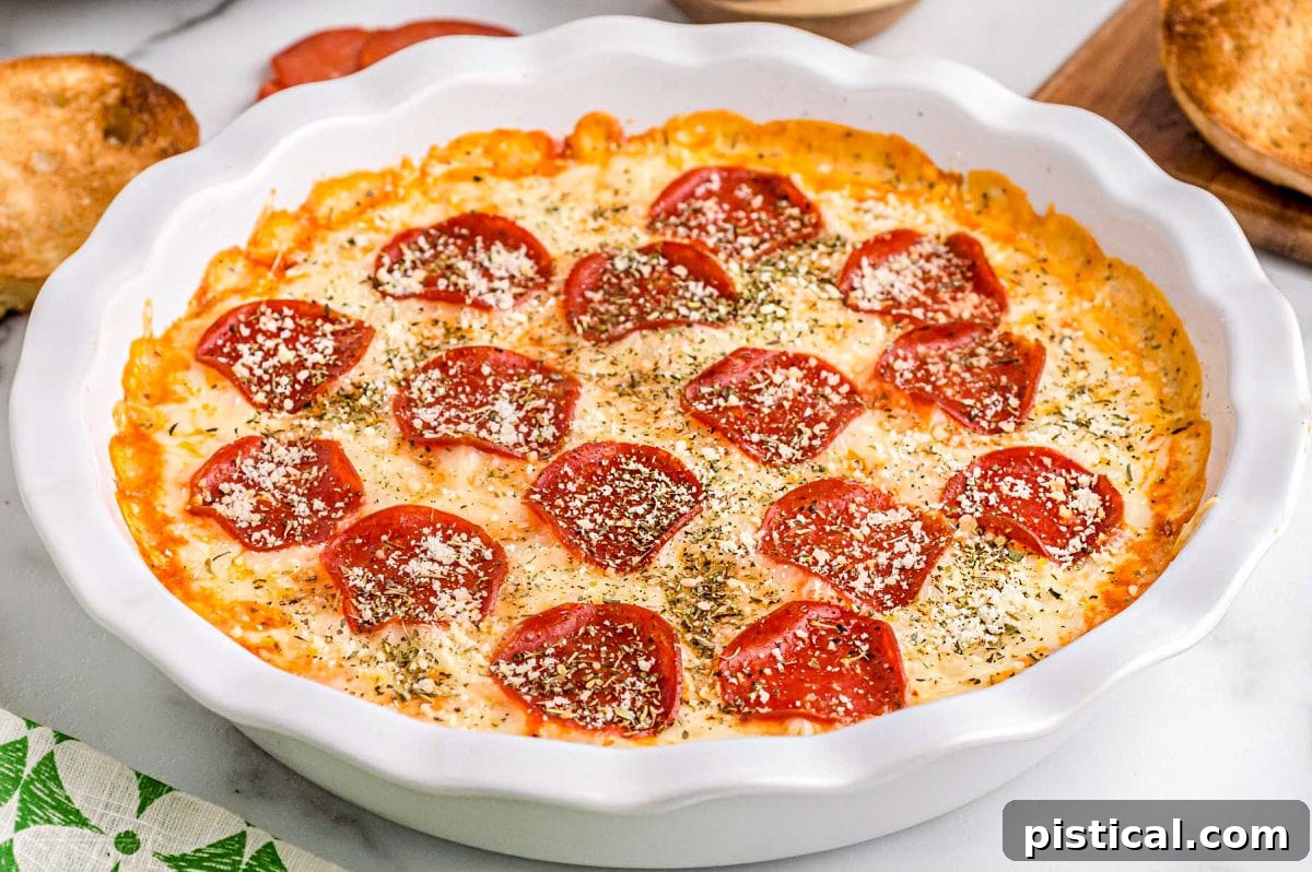 Ultimate Baked Pizza Dip 4 close up look at the baked pepperoni pizza dip topped with Italian seasoning and grated Parmesan cheese.