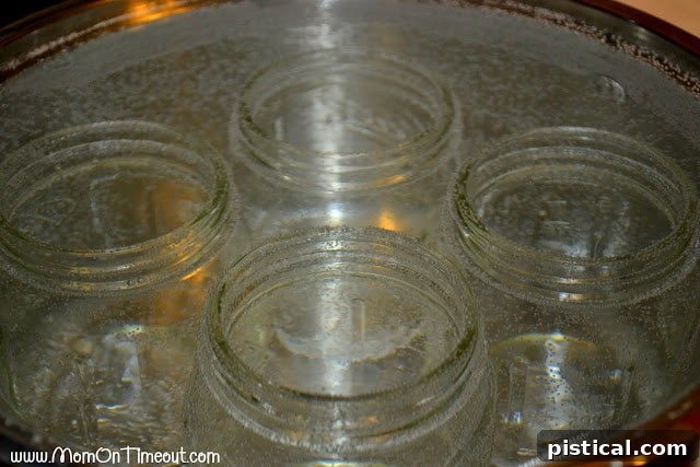 Glass jars being sterilized in a boiling water bath, essential for safe homemade canning.