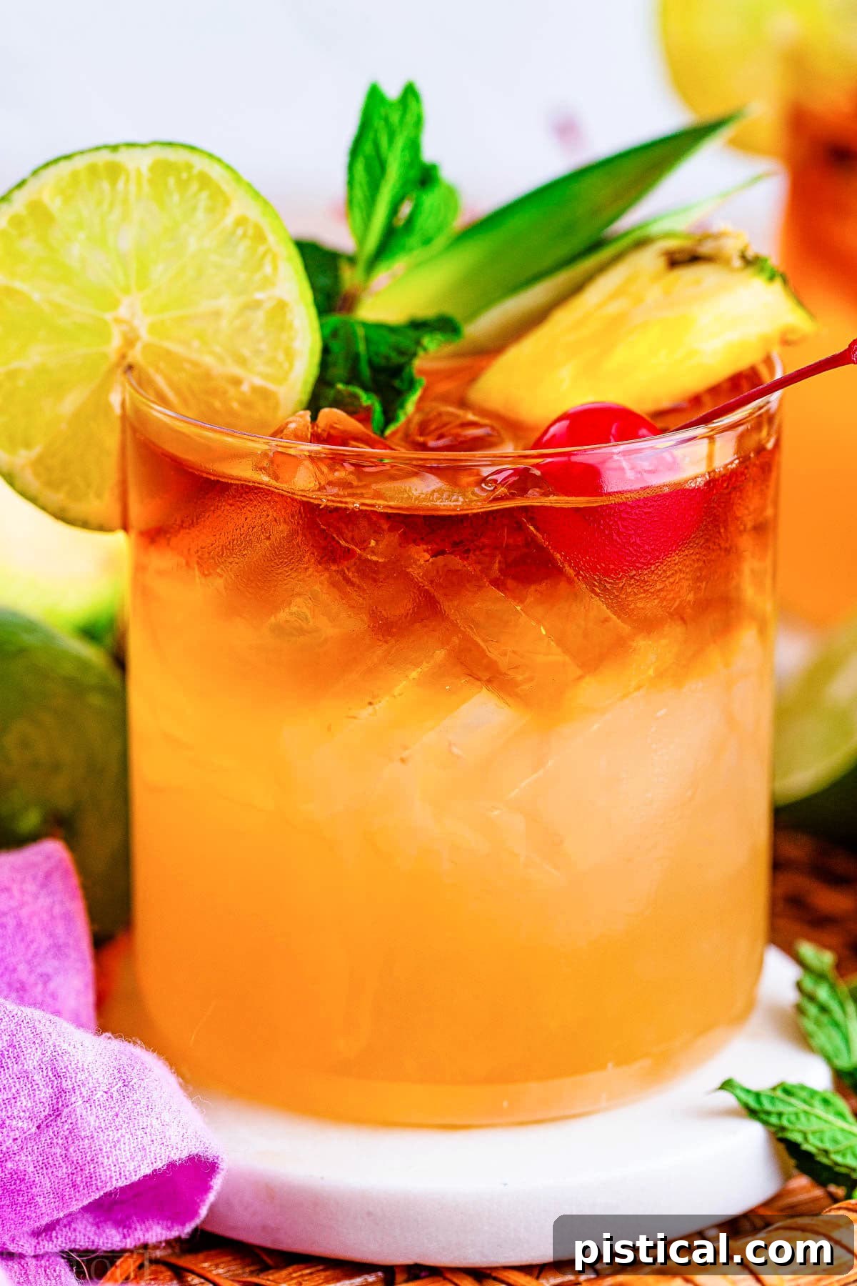 A vibrant close-up of a Mai Tai cocktail, generously adorned with a maraschino cherry, a juicy pineapple wedge, a fresh lime slice, and a sprig of mint, showcasing its delightful presentation.